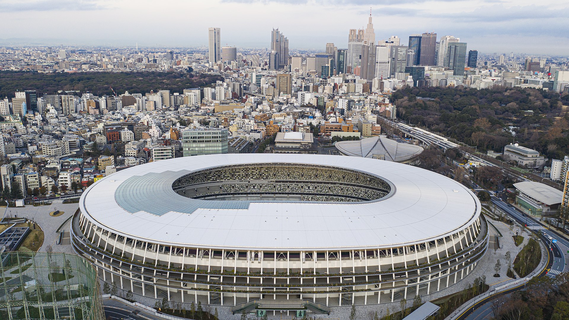 国立競技場の全景。木の軒庇が層をなす楕円のスタジアム